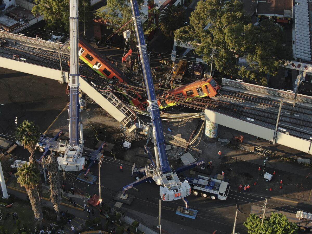 Vista aérea de vagones del metro colgando desde una sección elevada colapsada en la Ciudad de México