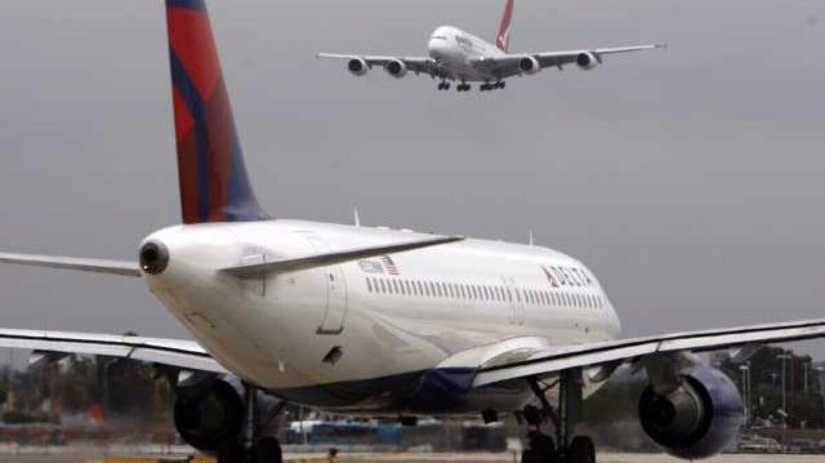 A Qantas A380 Airbus descends for landing while a Delta jet waits on a busy morning in 2009 at Los Angeles International Airport. (Mark Boster / Los Angeles Times)