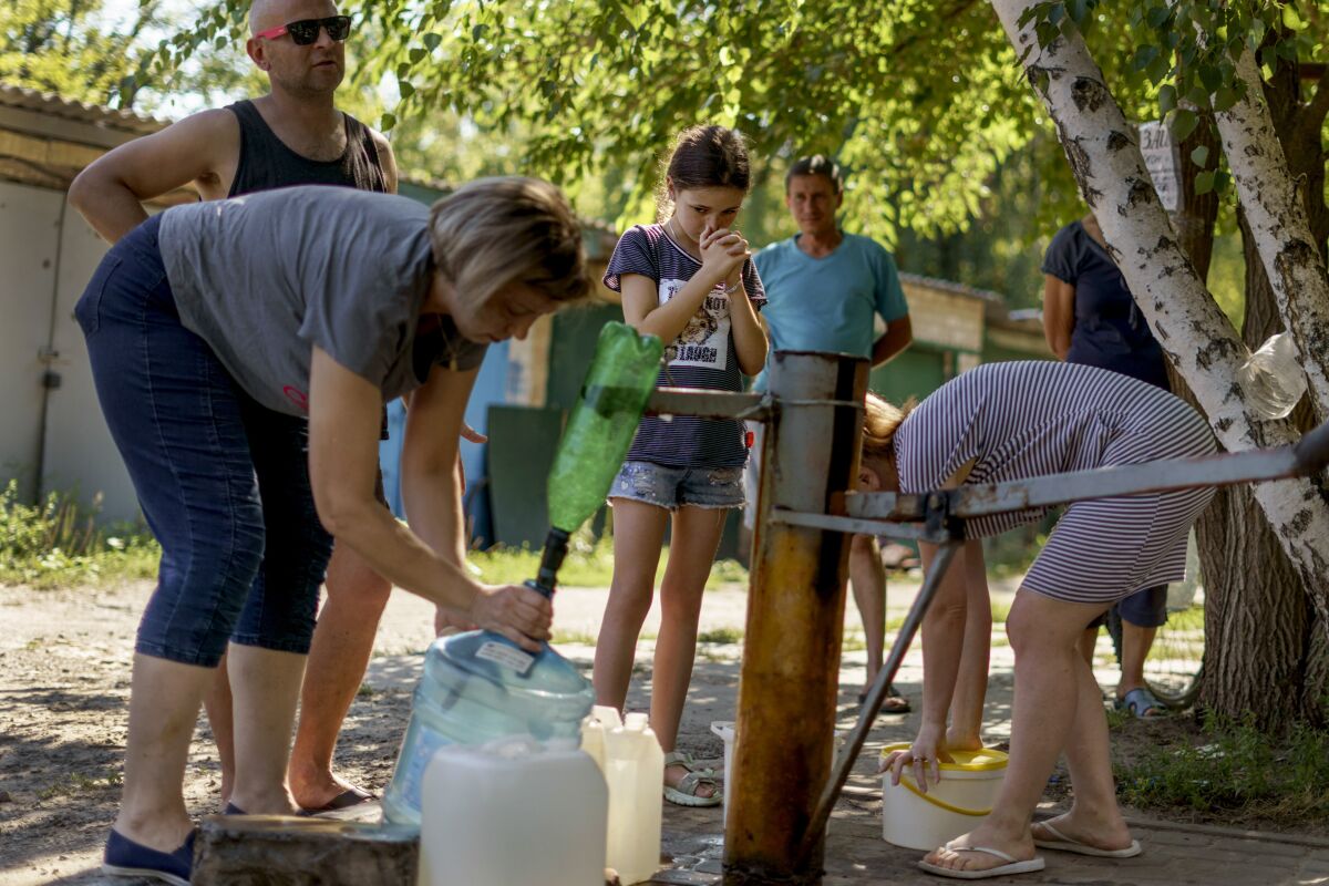 Residents filling containers with water from a well