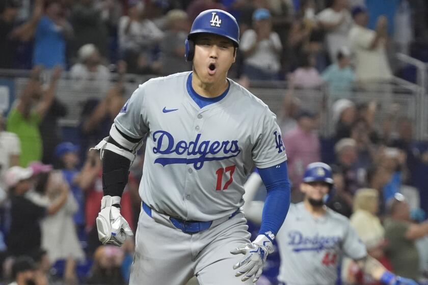 Dodgers' Shohei Ohtani reacts with his mouth wide open while running the 
bases after hitting his 50th home run of the year