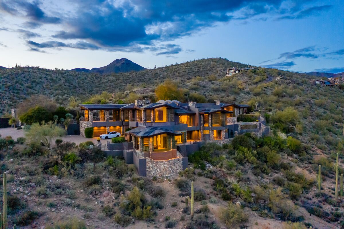 A photo of a two story mansion in a desert landscape
