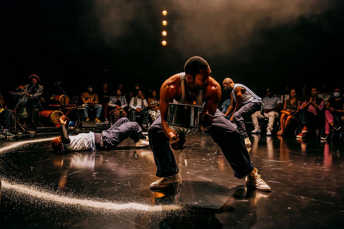 Three men in different plays and poses on stage in the 'The Brothers Size' at the Geffen Playhouse.