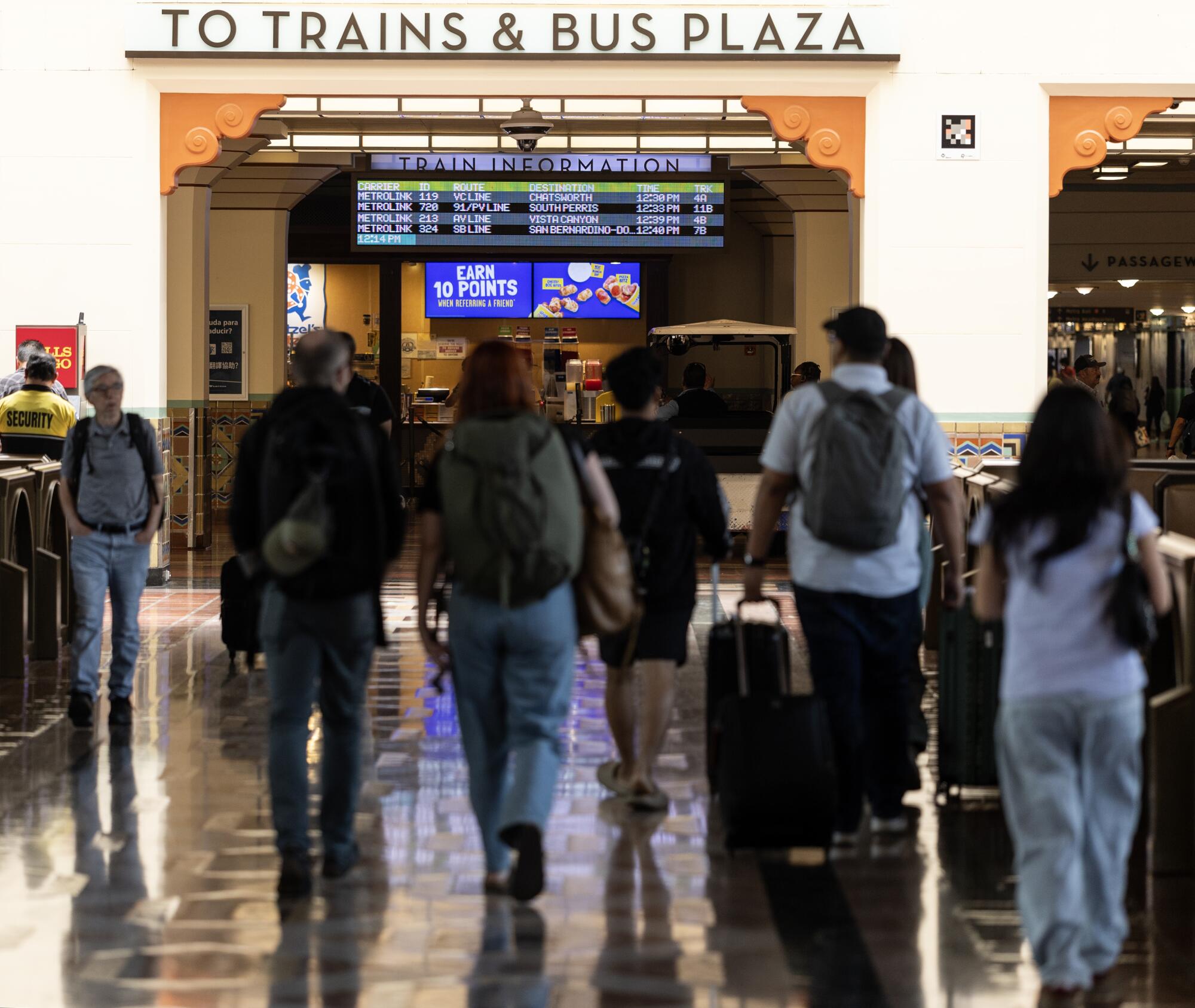People with backpacks and roller bags walk throughout Union Station.