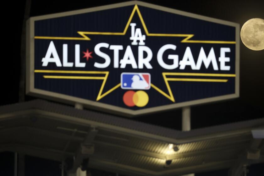 Los Angeles, CA - October 21: The moon rises behind the Los Angeles Dodgers All Star Game sign.
