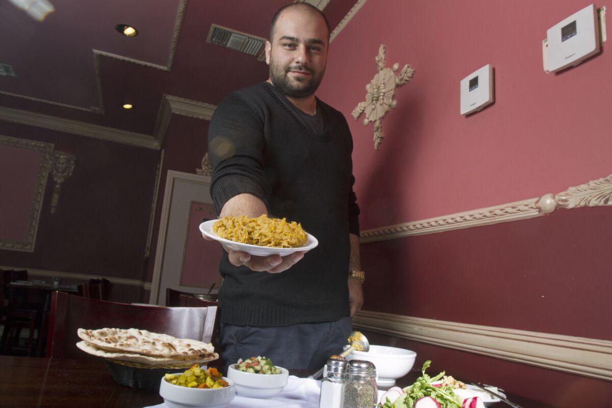 Co-owner Robert Abdian serves a plate of food at Nersses Vanak.