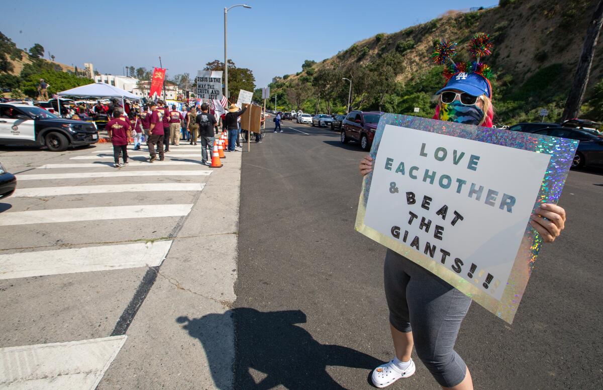 Jody Bender holds a sign for passing traffic near a gathering of Christian groups protesting near Dodger Stadium 