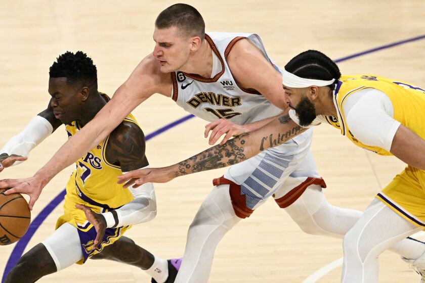 LOS ANGELES, CA - MAY 22: Los Angeles Lakers guard Dennis Schroder, left, battles for the loose ball with Denver Nuggets center Nikola Jokic, center, in front of forward Anthony Davis during the third quarter of game four in the NBA Playoffs Western Conference Finals at Crypto.com Arena on Monday, May 22, 2023 in Los Angeles, CA. (Gina Ferazzi / Los Angeles Times)