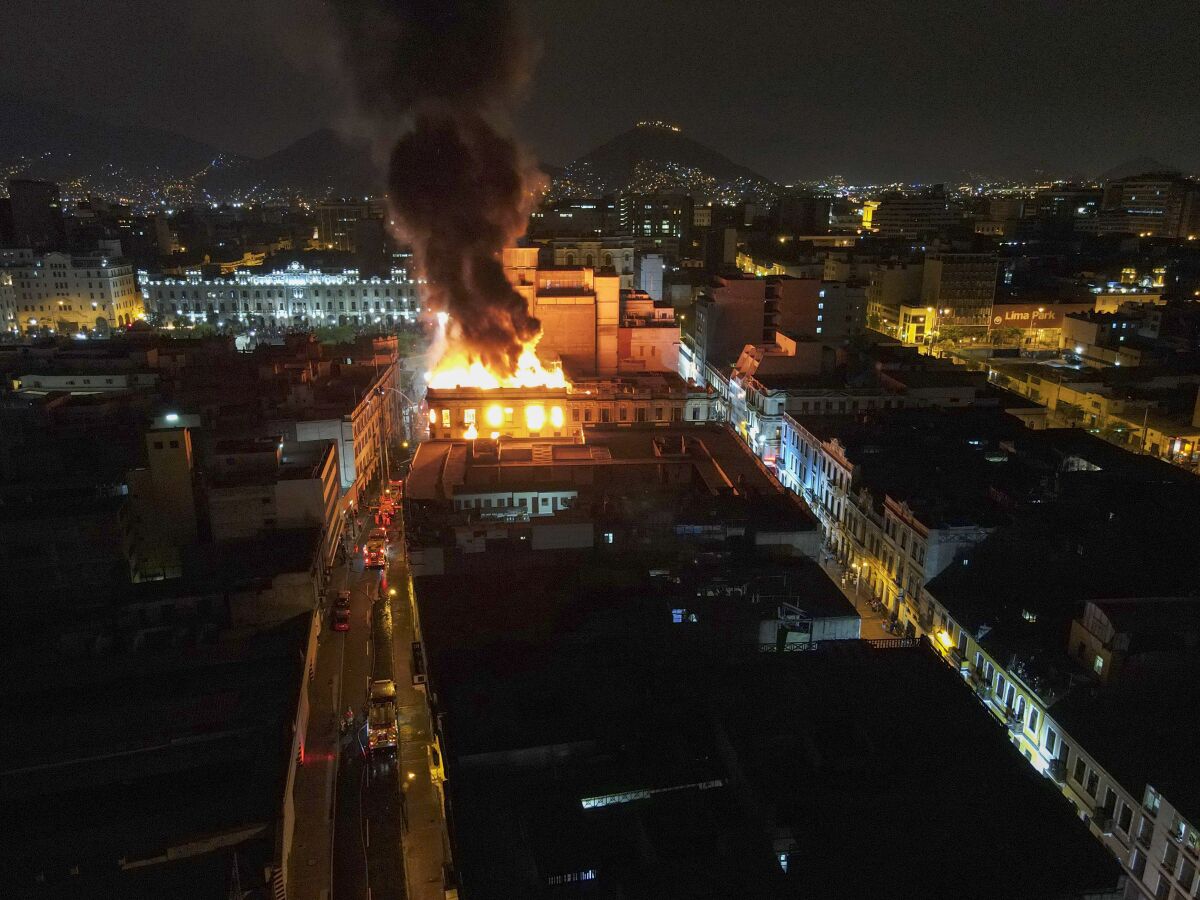 A building burns amid anti-government protests in downtown Lima, Peru, Thursday, Jan. 19, 2023. Protesters are seeking immediate elections, the resignation of President Dina Boluarte and the release from prison of ousted President Pedro Castillo. (AP Photo/Martin Mejia)