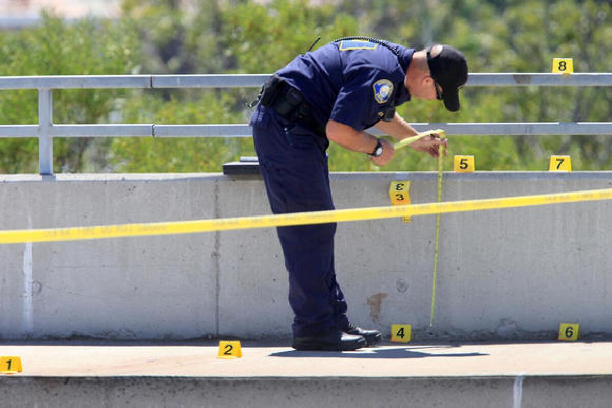 A Newport Beach police crime scene investigator takes notes Monday along the eastbound side of Pacific Coast Highway. A woman's body was found nearby Monday morning.