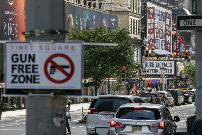 FILE— A sign reading "Gun Free Zone" is posted near around Times Square, Aug. 31, 2022, in New York.A federal judge said New York gun rules that dramatically restrict where people can carry weapons and require concealed carry permit applicants to hand over social media information should be put on hold, Thursday, Oct. 6, 2022. (AP Photo/Yuki Iwamura, File)