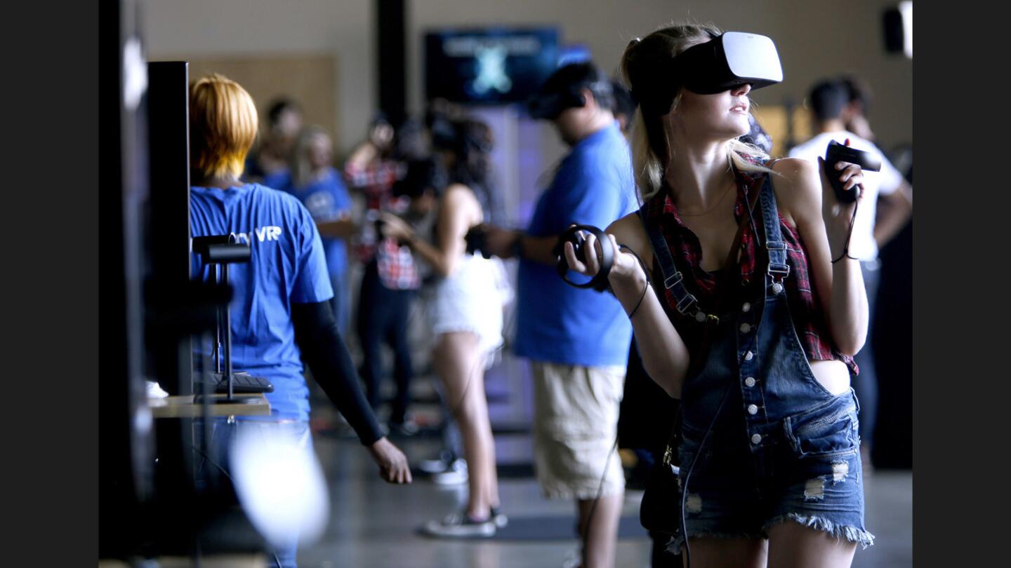 Nicole McMahon, 26 of Yucaipa, turns around to see whats behind her while playing Oculus Rift First Contact virtual reality game at the iBuyPower Gamefest, at the Orange County Fair in Costa Mesa on Saturday, Aug. 12, 2017.