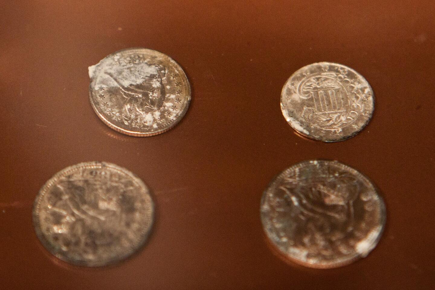 Silver and copper coins dating from 1652 to 1855, found in a 1795 time capsule, are displayed at the Museum of Fine Arts on Jan. 6, 2015 in Boston