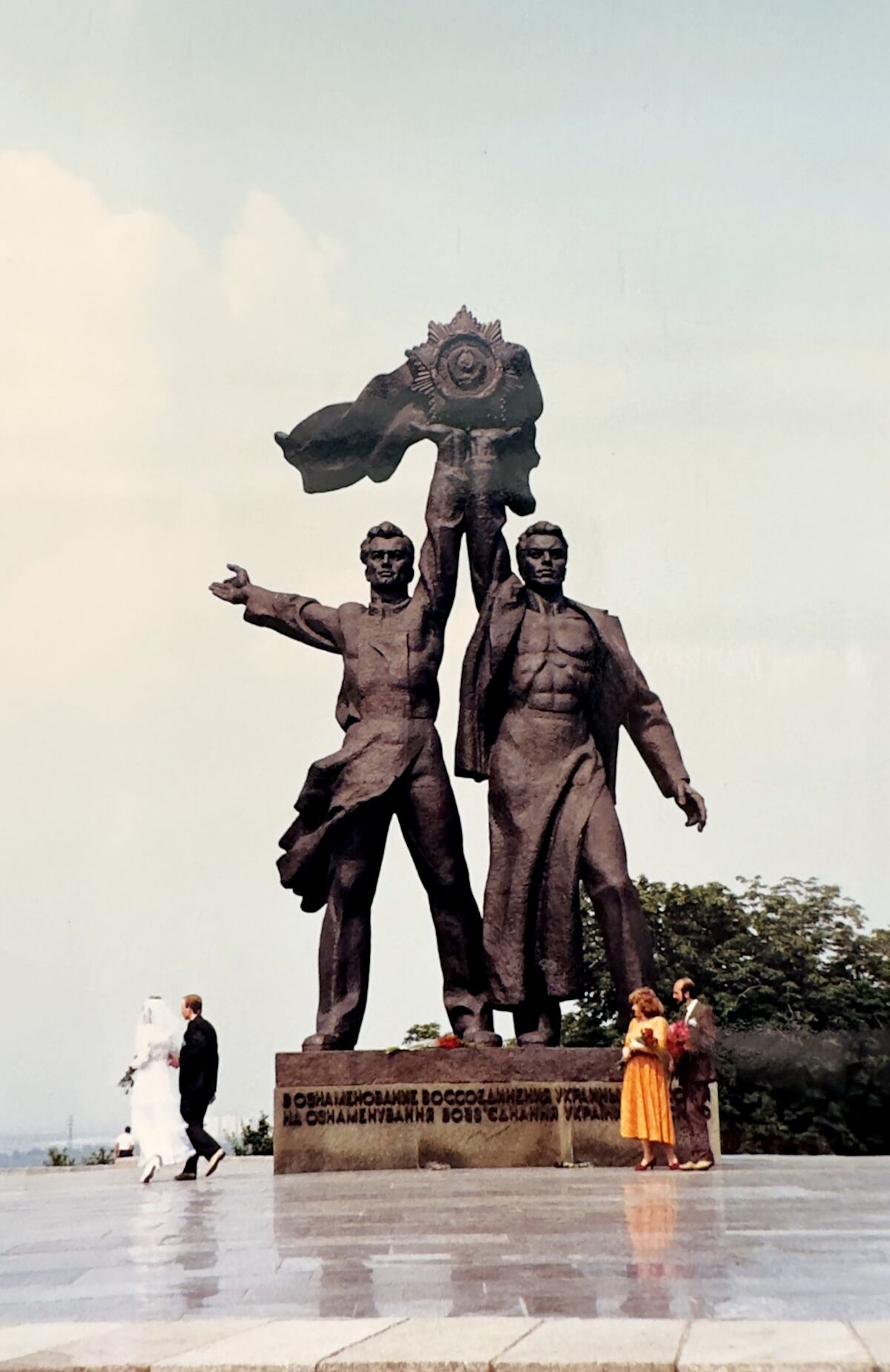 A 1998 photo shows newlyweds laying flowers by a Soviet-era bronze statue of Russian and Ukrainian workers standing in unity.