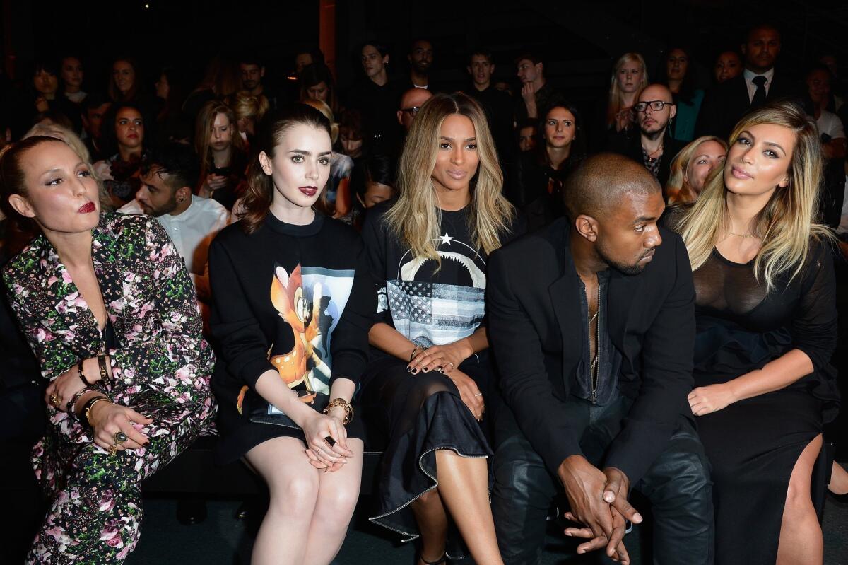 Actresses Noomi Rapace, left, Lily Collins, singer Ciara, Kanye West and Kim Kardashian attend the Givenchy show Sunday during Paris Fashion Week.