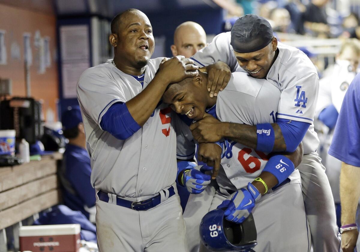 Dodgers outfielder Yasiel Puig, center, is congratulated by teammates Juan Uribe, left, and Hanley Ramirez after hitting a home run during the eighth inning of the Dodgers' 6-4 win over the Miami Marlins on Tuesday.