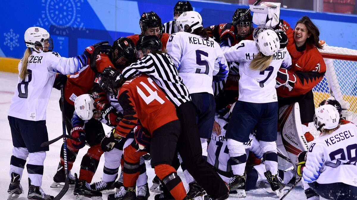 Players pile up on the Canadian goal in the women's preliminary round ice hockey match between the US and Canada during the Pyeongchang 2018 Winter Olympic Games on Thursday.