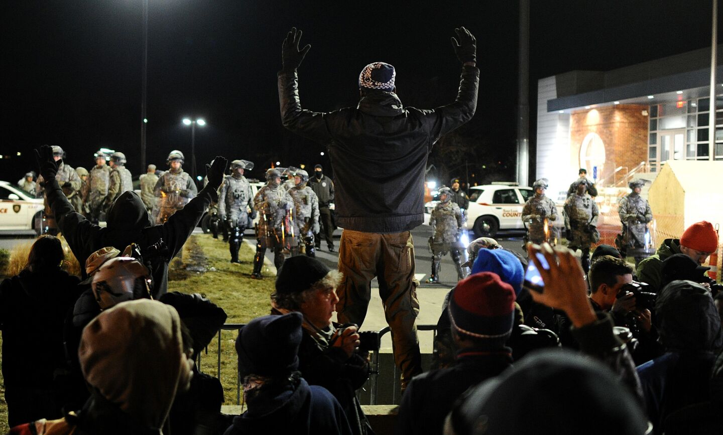 Protesters raise their hands outside the Ferguson police station on Nov. 25.