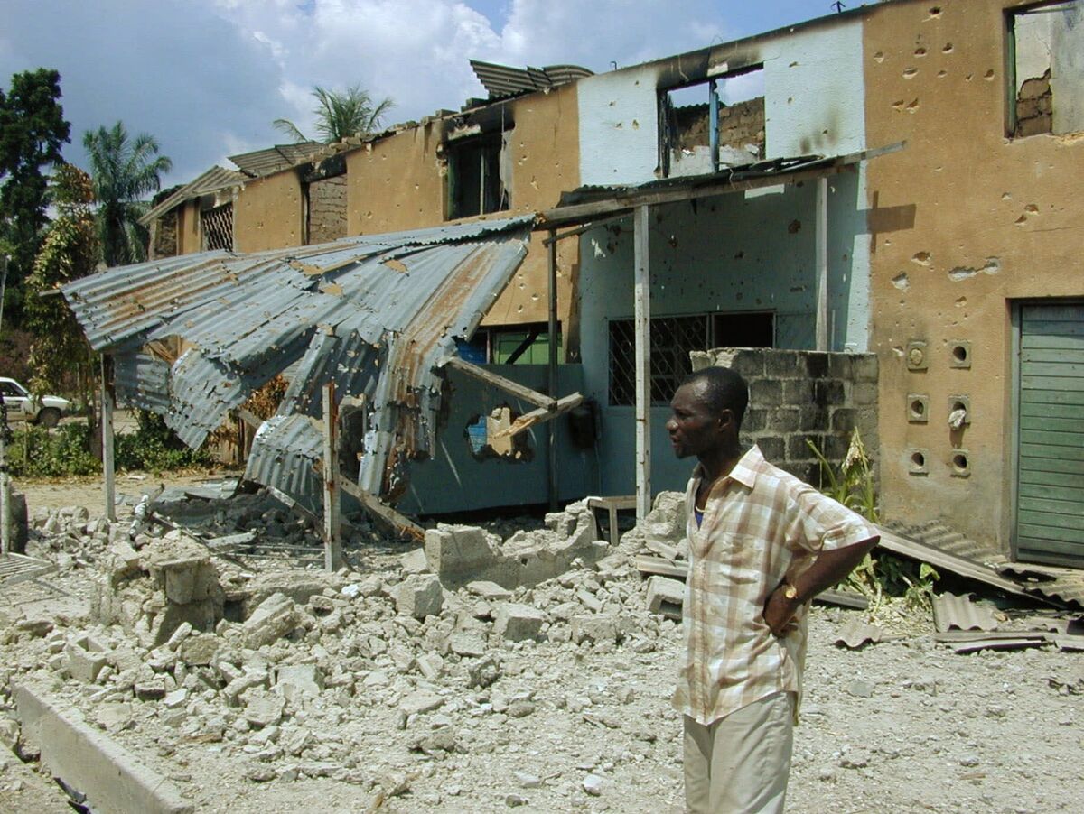 FILE - A Congolese man looks at the destruction of the Tshopo neighborhood of Kisangani, where Rwandan and Ugandan armies had battled for a week before the Rwandans succeeded in pushing the Ugandan soldiers out, in Kisangani, Congo on June 11, 2000. The International Court of Justice on Wednesday, Feb. 9, 2022 ordered Uganda to pay $325 million in compensation to its neighbor Congo for violence in a long-running conflict between the African neighbors that began in the late 1990s. (AP Photo/Hrvoje Hranjski, File)