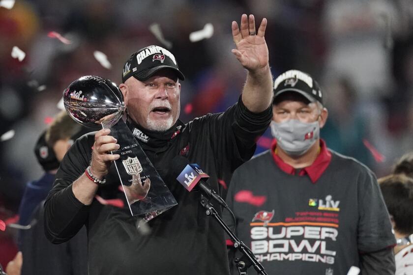 Tampa Bay Buccaneers head coach Bruce Arians holds up the Vince Lombardi trophy after defeating the Kansas City Chiefs.