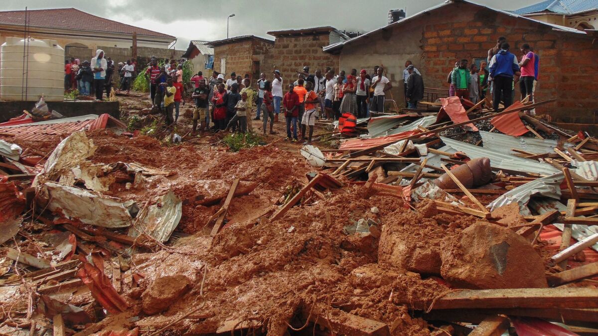 Residents of Freetown view damage to property after an Aug. 14 mudslide in the suburb of Regent in Freetown, Sierra Leone.