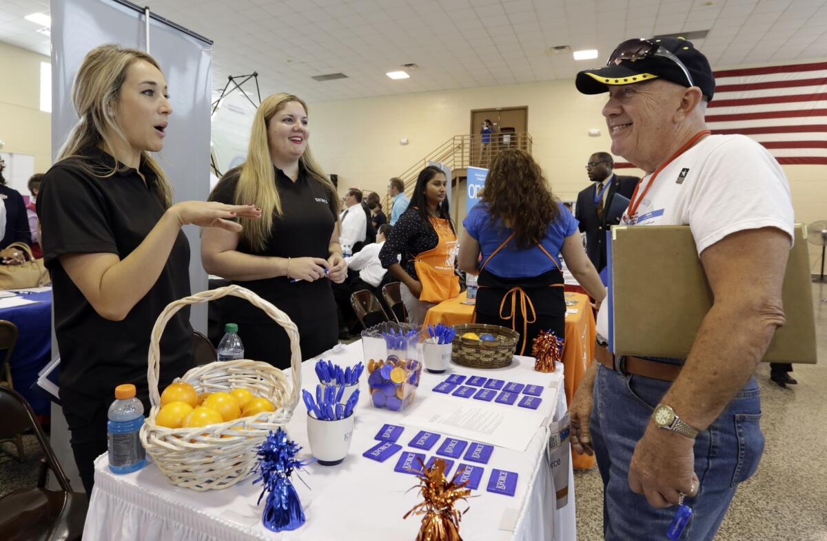 Army veteran John Godman talks to recruiters Nicole Rushton, left, and Megan Hogan at a Hiring Fair For Veterans in Fort Lauderdale, Fla., on July 16.