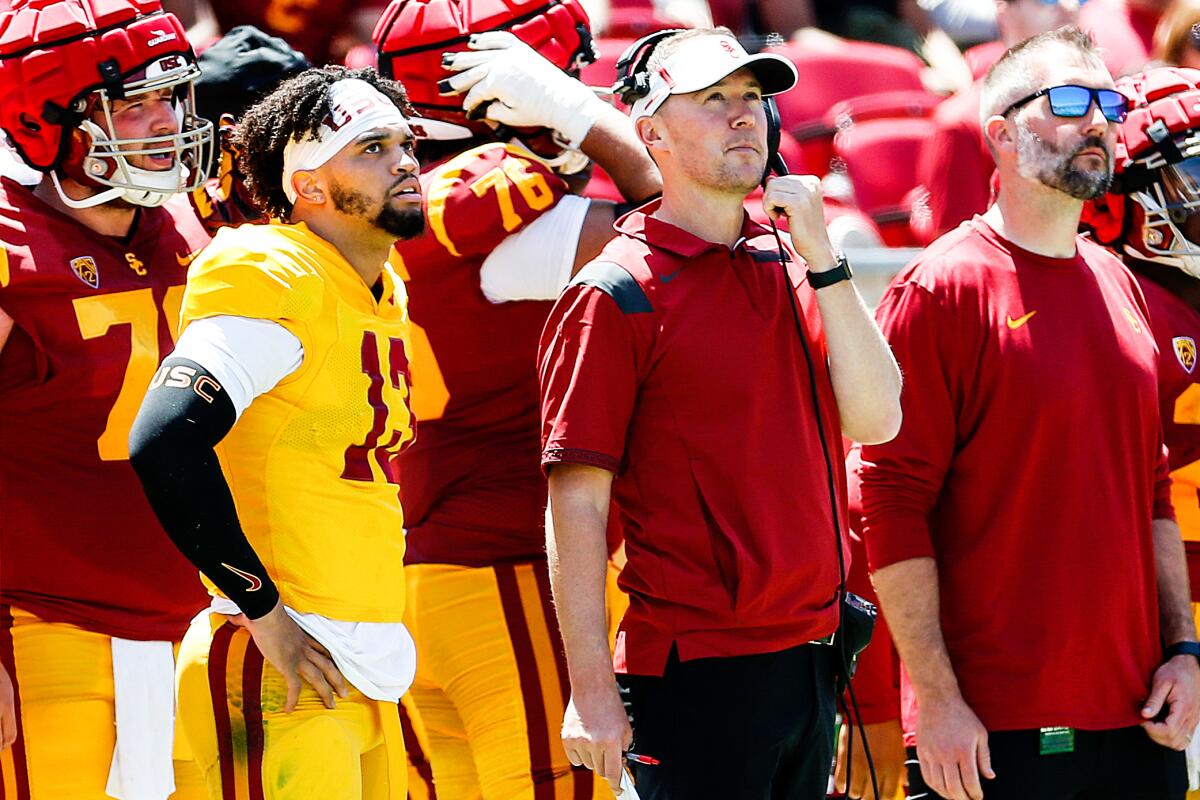 USC quarterback Caleb Williams, left, and USC coach Lincoln Riley stand on the sideline.