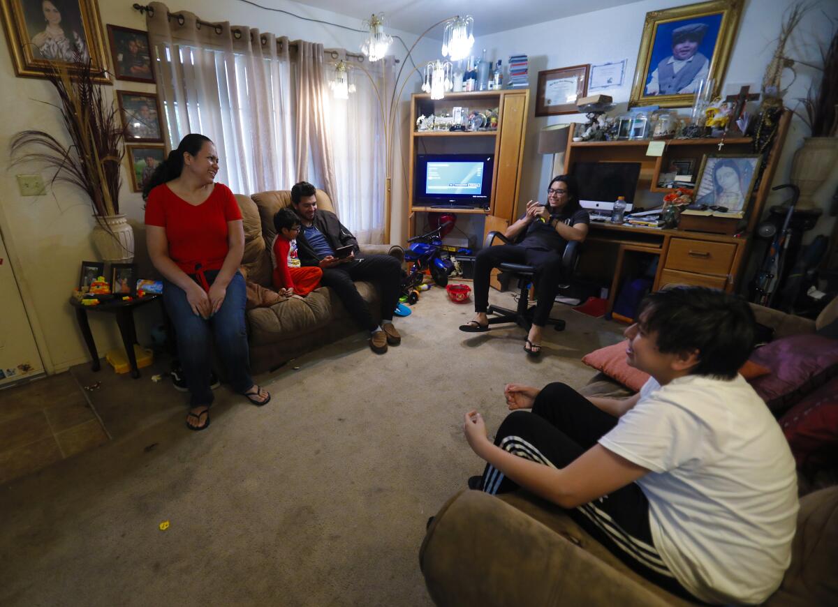 Maria Peñuelas, 45, sits in their living room with her four boys on April 30. 