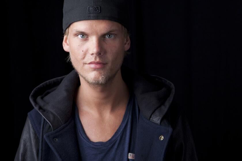 FILE - In this Aug. 30, 2013 file photo, Swedish DJ, remixer and record producer Avicii poses for a portrait, in New York. Avicii first posthumous single will be released next week and a full album will be out in June. Collaborators of the DJ-producer say in a statement Friday, April 5, 2019, that Avicii was close to completing his new album before he died last April. His co-writers continued to work on the nearly finished songs and a new single, SOS, will drop on April 20. (Photo by Amy Sussman/Invision/AP, File)