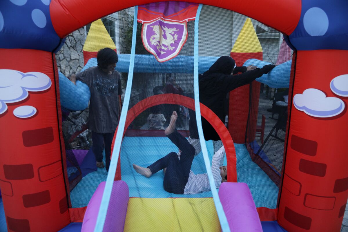 Children play in a castle-themed bounce house