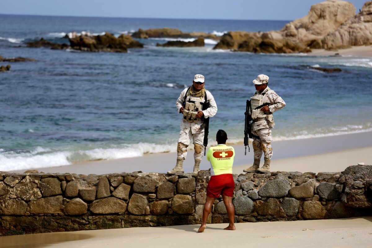 Mexican soldiers patrol Palmilla Beach, where three men were killed by a group of men with automatic weapons in San Jose del Cabo. (Gary Coronado / Los Angeles Times)
