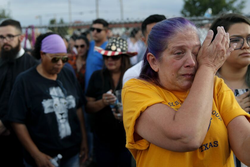 Cathe Hill wipes tears from her eyes during a vigil for victims of Saturday's mass shooting at a shopping complex Sunday, Aug. 4, 2019, in El Paso, Texas. "There's no such thing as a stranger here in El Paso," said Hill about the impact the shooting had on the community. (AP Photo/John Locher)