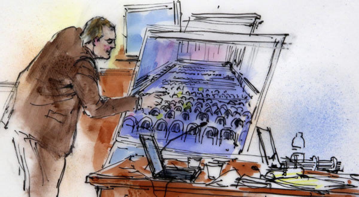 This courtroom sketch shows Aurora Police Detective Matthew Ingui pointing to a large photograph of the inside of the Century 16 theater.
