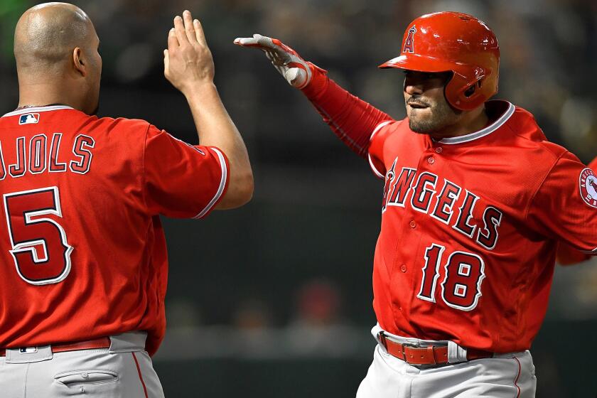 Angels catcher Geovany Soto (18) is congratulated by teammate Albert Pujols after hitting what proved to be game-winning, two-run home run against the A's in the ninth inning Tuesday.