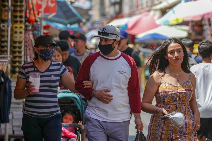 Shoppers in mask and without masks in a very congested market Santee Alley
