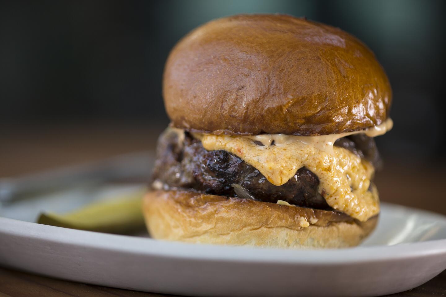 The deer burger is served with pimento cheese, charred onion and spicy mayo at Manuela.