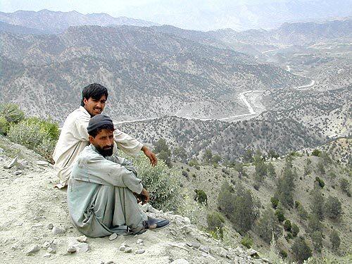 REMOTE TERRAIN: Afghan men sit on a bluff overlooking the road linking Gardez and Khowst. U.S. troops were determined to secure key checkpoints along the road that were used by warlords for extortion. Two detainee deaths linked to a Green Beret unit from Alabama came as a consequence of efforts to pacify the route.