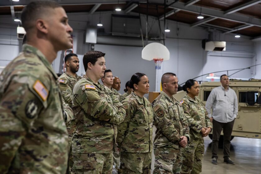 National Guard officers listen as Gov. Gavin Newsom speaks at a press conference announcing a $30 million investment to expand the state's National Guard efforts in preventing drug trafficking at a National City National Guard Armory in National City on Sunday.