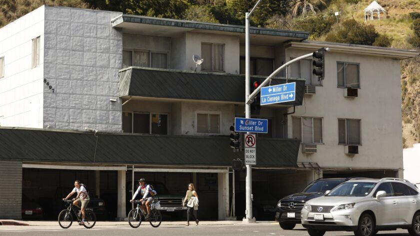 Pedestrians walk by an apartment on West Hollywood's list of buildings possibly at risk in an earthquake. Under a new law, the building will need to be professionally evaluated to determine if it needs to be seismically retrofitted.