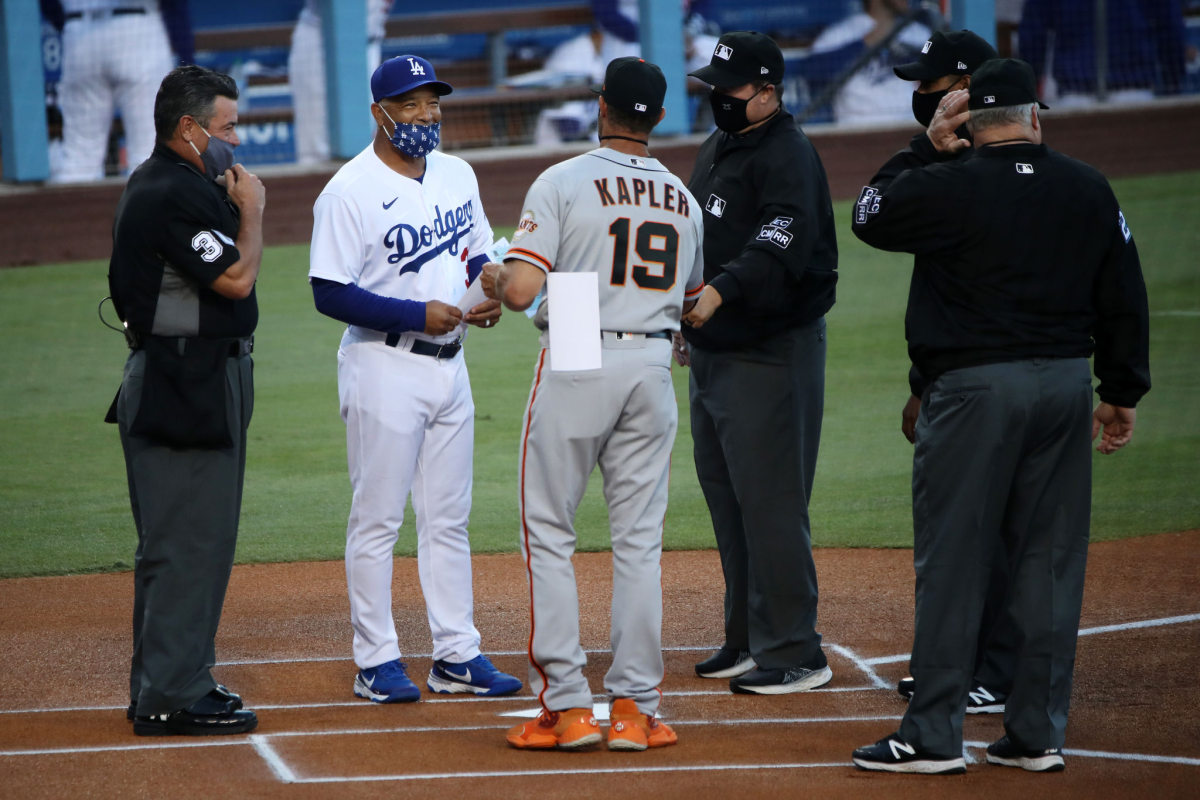 Dodgers manager Dave Roberts, left, and Giants manager Gabe Kapler exchange lineups before a game in July 2020.