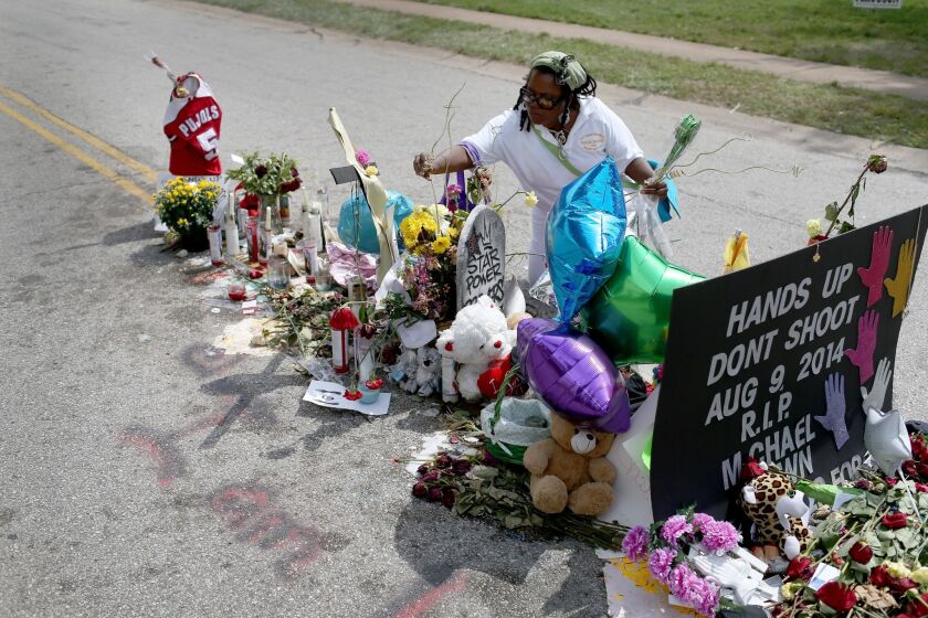 Beverly Scott of Chicago adds to the makeshift memorial in Ferguson, Mo., for Michael Brown.