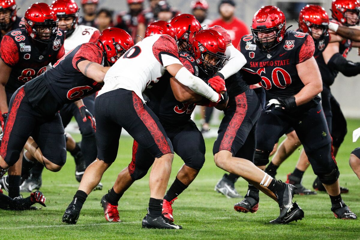 San Diego State's Martin Blake (center) runs through a host of defenders during Spring game at Snapdragon Stadium.