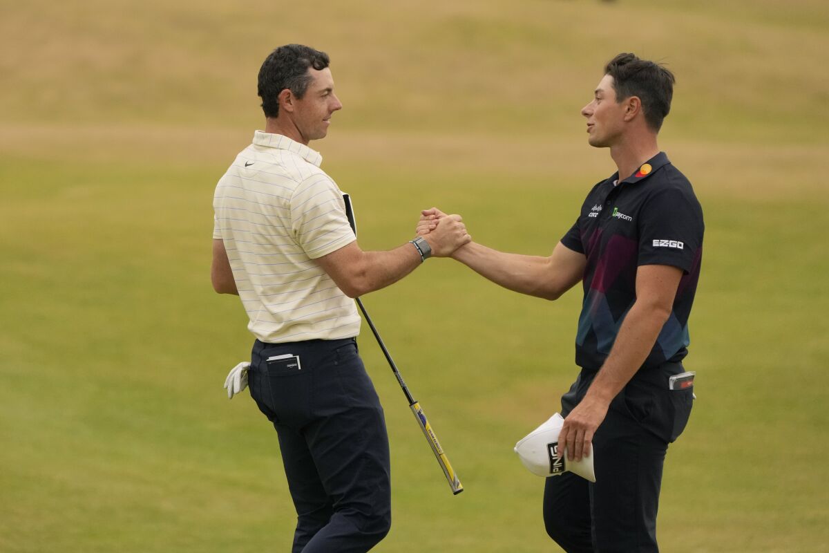Rory McIlroy and Viktor Hovland shake hands on the golf course.