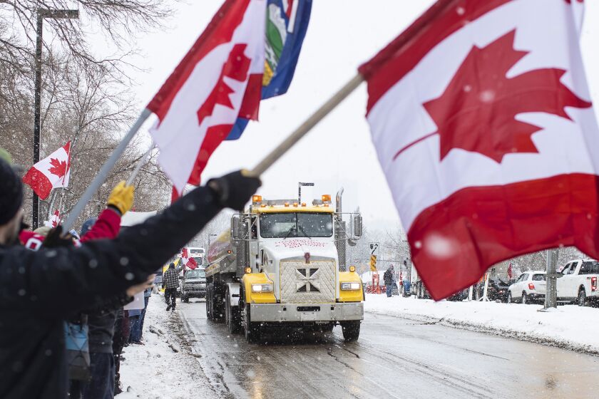 People gather in protest against COVID-19 mandates and in support of a protest against COVID-19 restrictions taking place in Ottawa, in Edmonton, Alberta, Saturday, Feb. 5, 2022. (Jason Franson/The Canadian Press via AP)