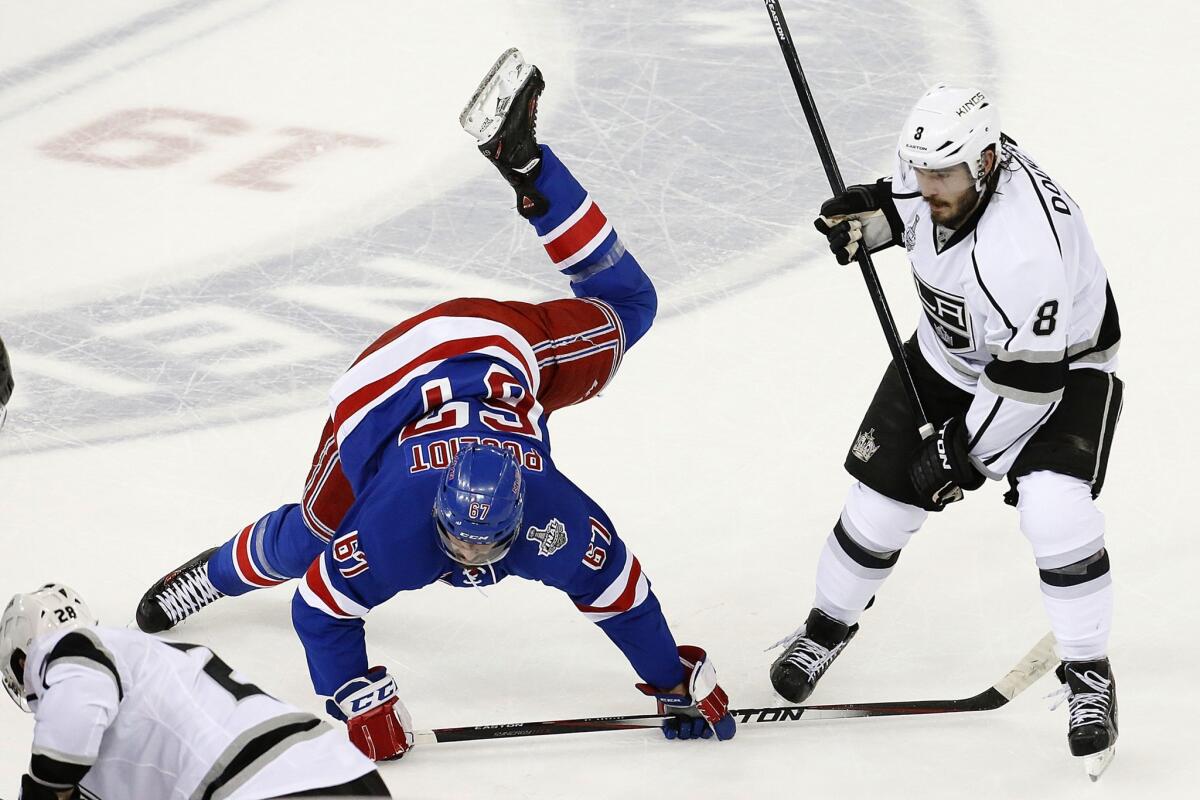 Kings defenseman Drew Doughty, right, knocks New York Rangers forward Rick Nash to the ice during the first period of the Kings' 3-0 win in Game 3 of the Stanley Cup Final.