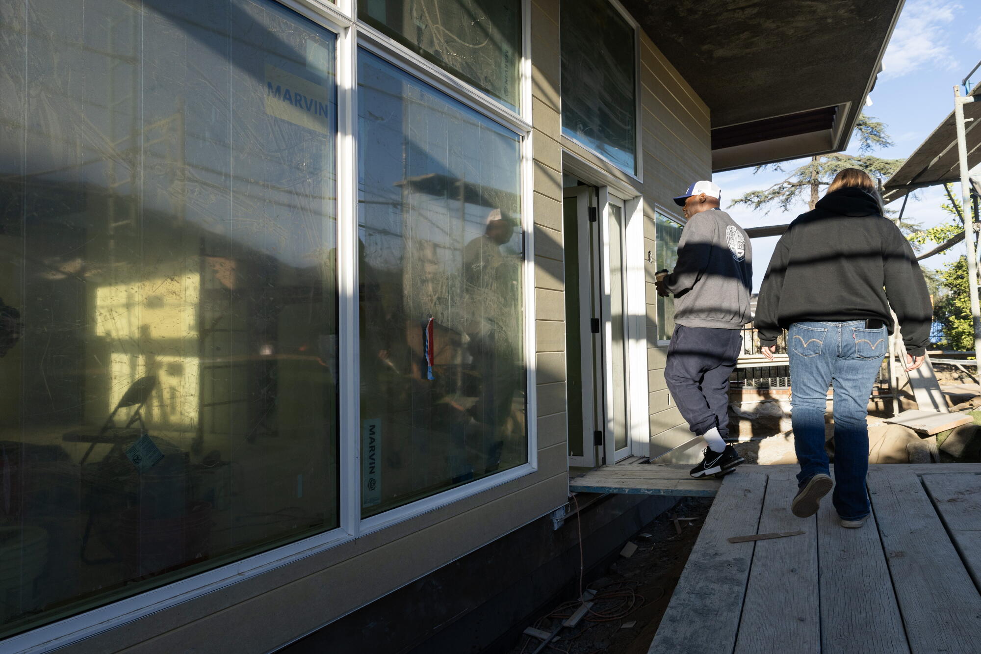Anthony Ruffin and wife Jonni Miller walk into their house that is close to being finished in Altadena.