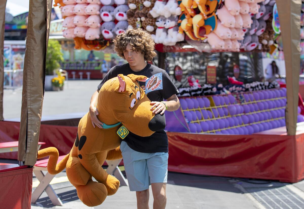 Joe Bullock, 15, of San Clemente, carries an oversized stuffed Scooby Doo his grandfather won at the O.C. Fair.