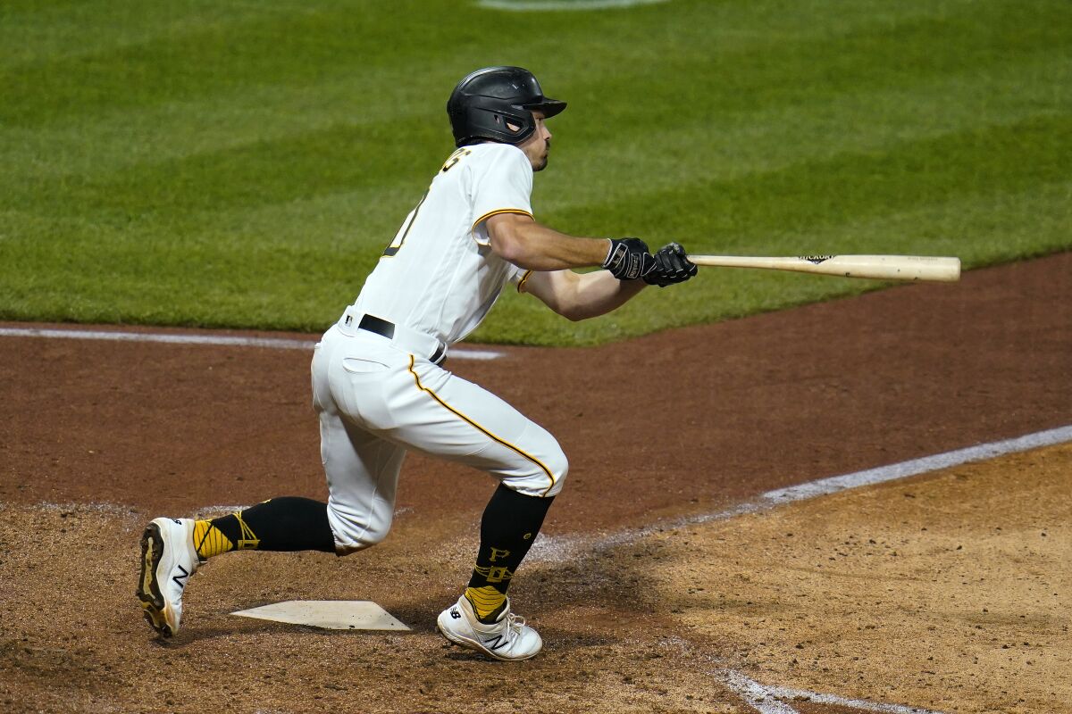 Pittsburgh Pirates' Bryan Reynolds triples to right field, off Cincinnati Reds relief pitcher Tony Santillan, driving in a run, during the sixth inning of a baseball game in Pittsburgh, Saturday, Oct. 2, 2021. (AP Photo/Gene J. Puskar)