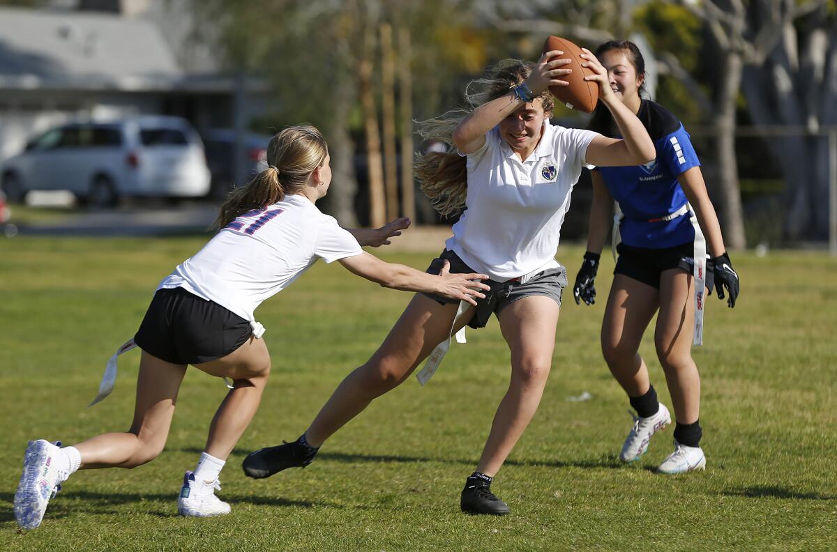 Capri Cuneo eludes a defender during the Seals 13U girls’ flag football practice at Mariners Park on April 5.