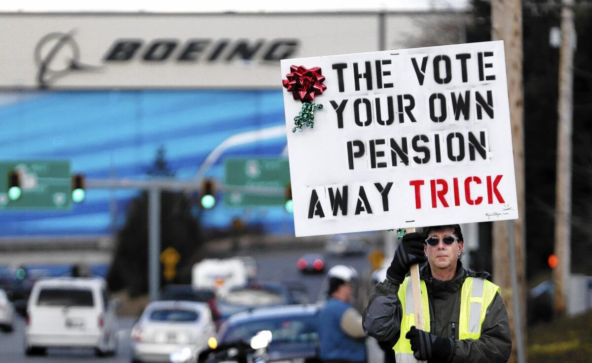 Machinists union member Kevin Flynn protests Boeing's last contract offer in Everett, Wash. Members will vote Jan. 3 on the proposal. It includes the jobs that would come with the company’s new 777X airliner plant, but local union leaders are unhappy with other terms. California and other states are also vying for the plant.