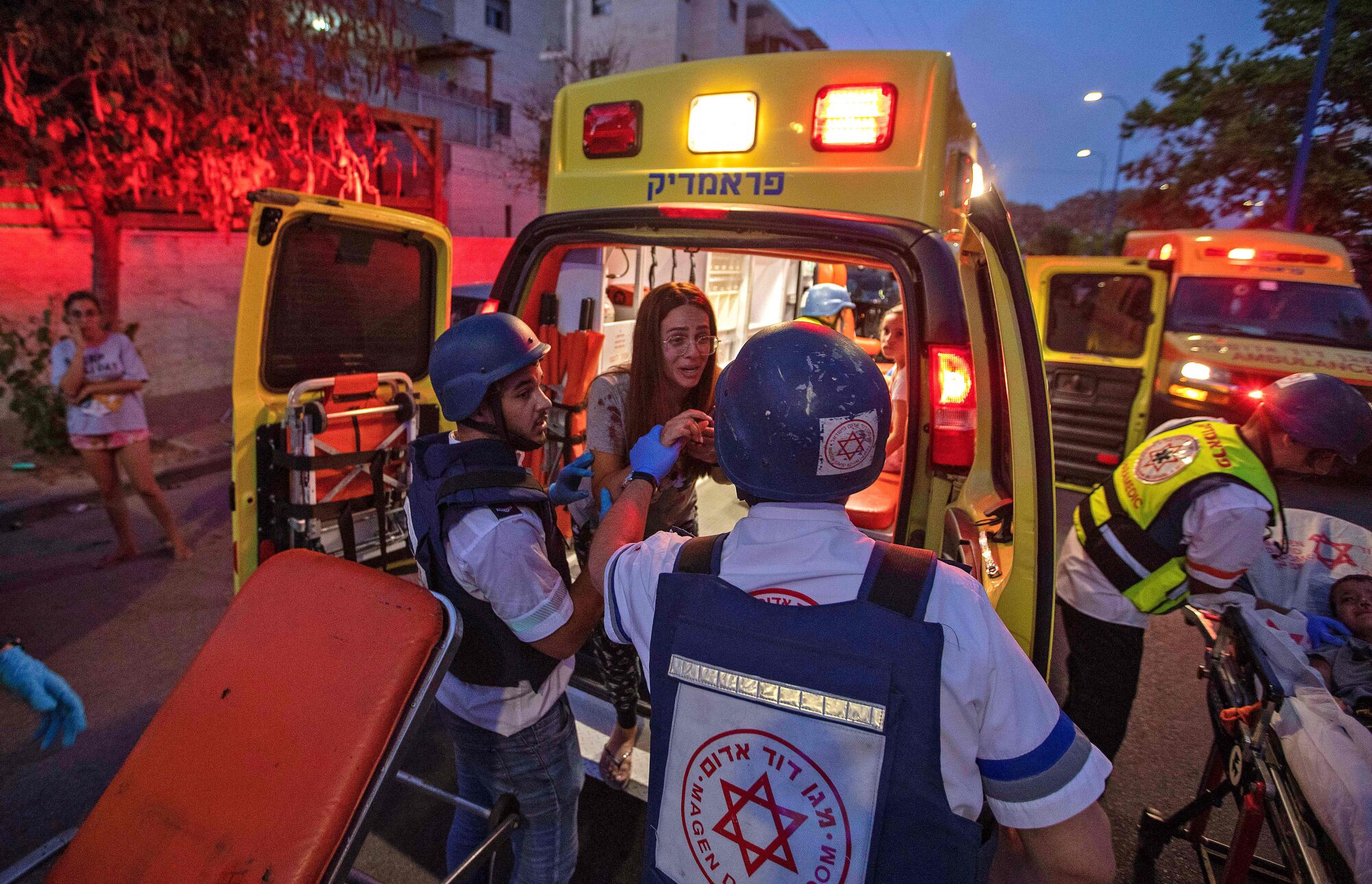 Rescue workers evacuate a woman by ambulance